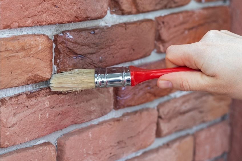 Clean the Surface of the Brick Wall with a Brush